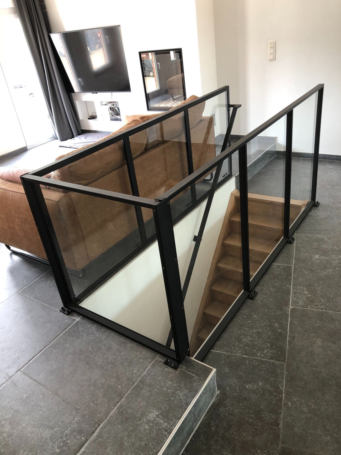 Zwarte stalen balustrade met glazen panelen rond een binnentrap