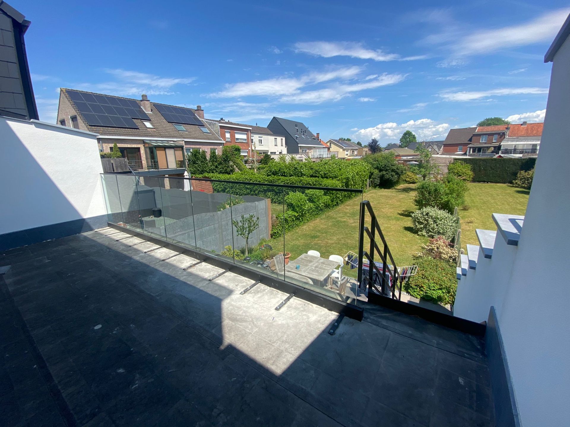Glazen balustrade zonder spijlen op een terras met zicht op de tuin