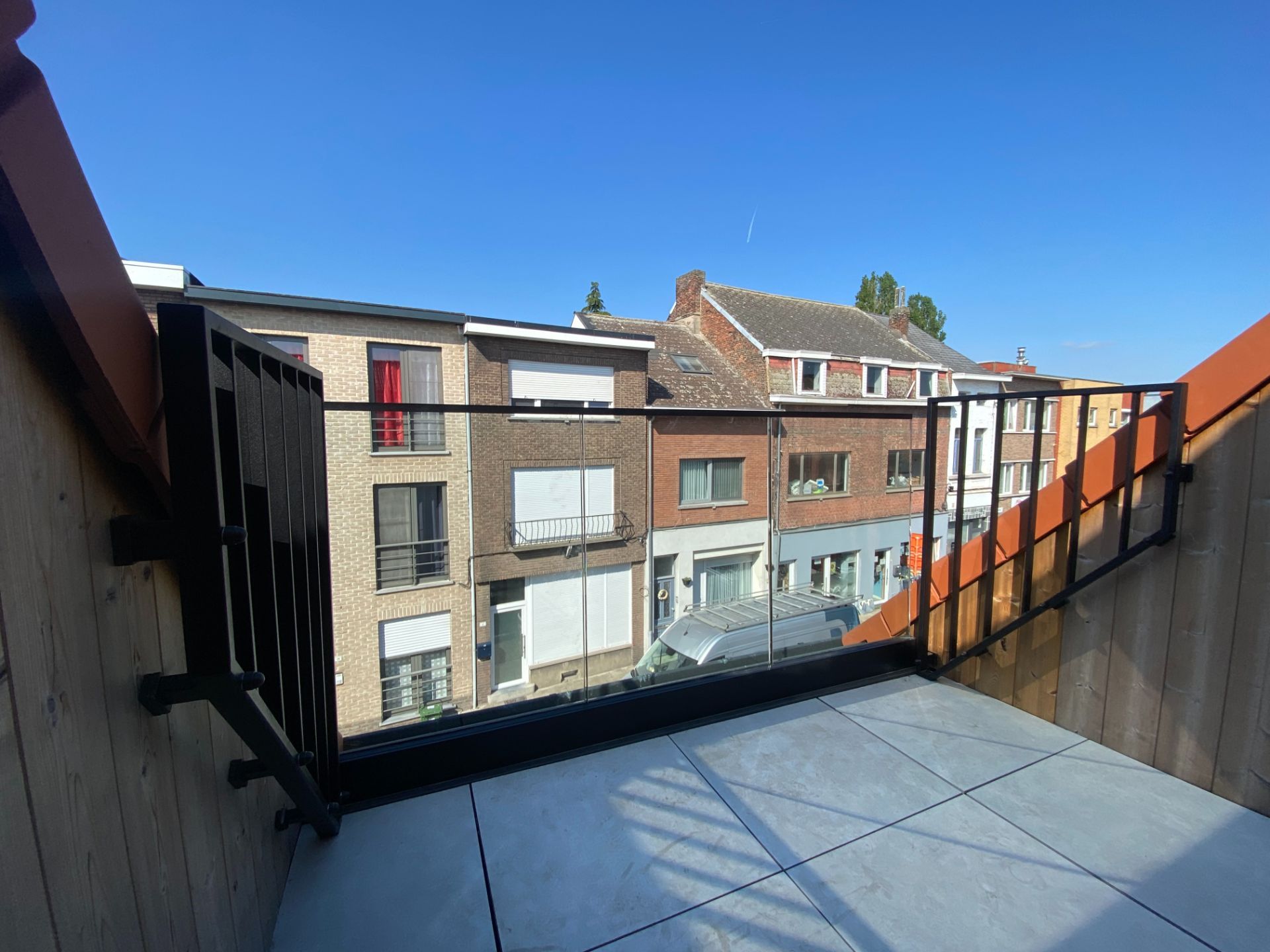 Glas tussen zwarte stalen zijpanelen op een terras in de stad