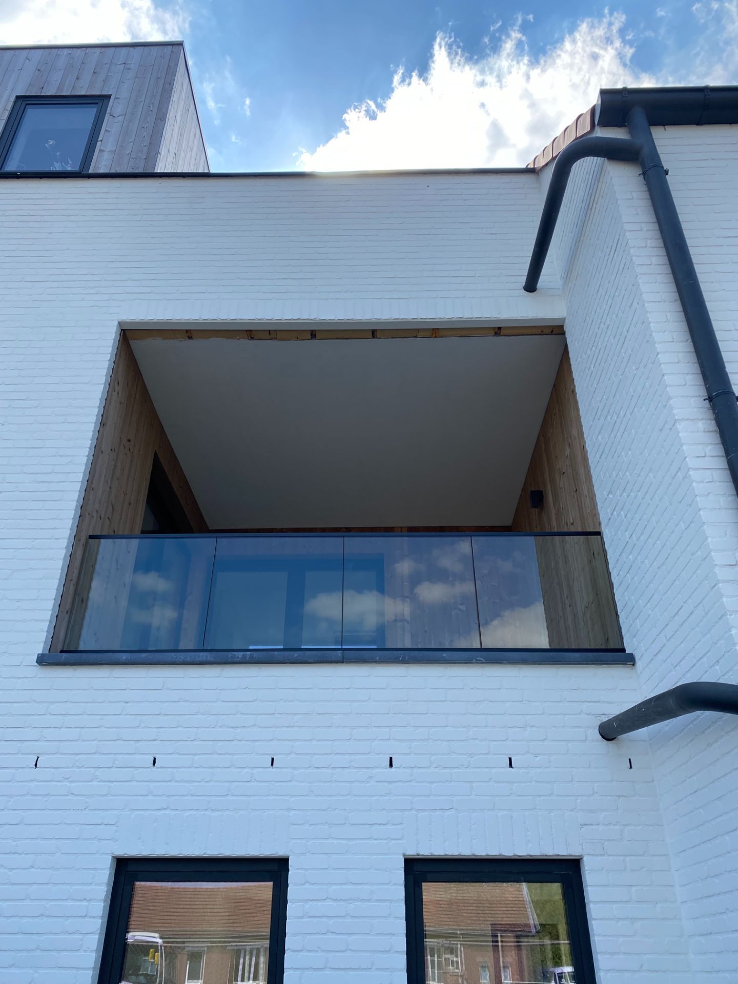 Glazen balustrade aan een inpandig terras op de verdieping